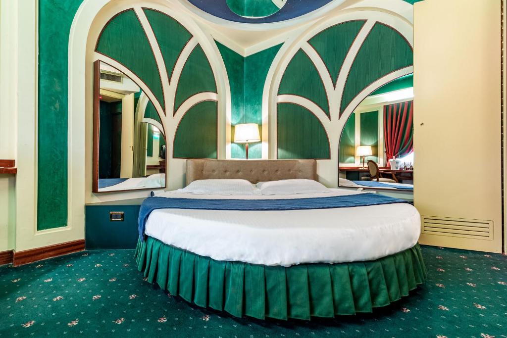 um quarto com uma cama grande e uma parede verde em Hotel Motel Miami em Limito di Pioltello