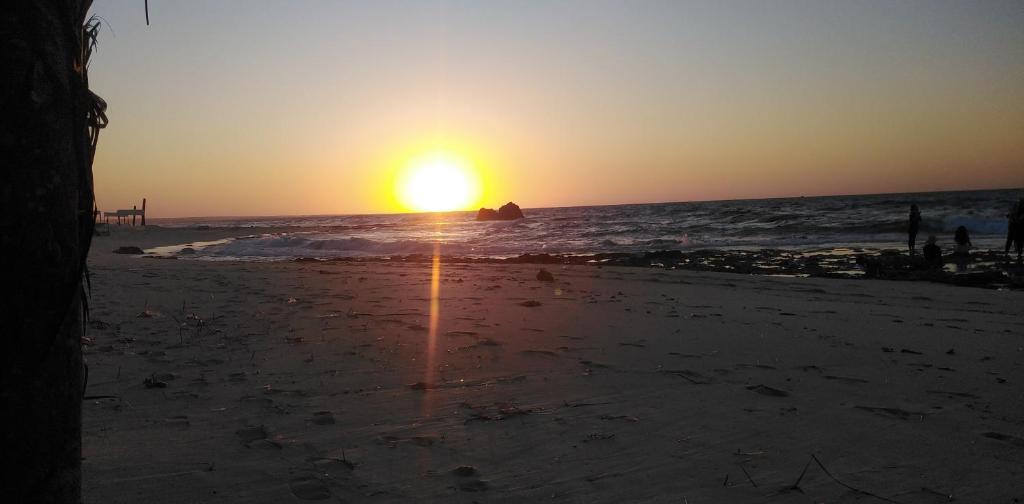 una puesta de sol en una playa con el océano en شقة فندقية - برج نجمة القصر, en Marsa Matruh