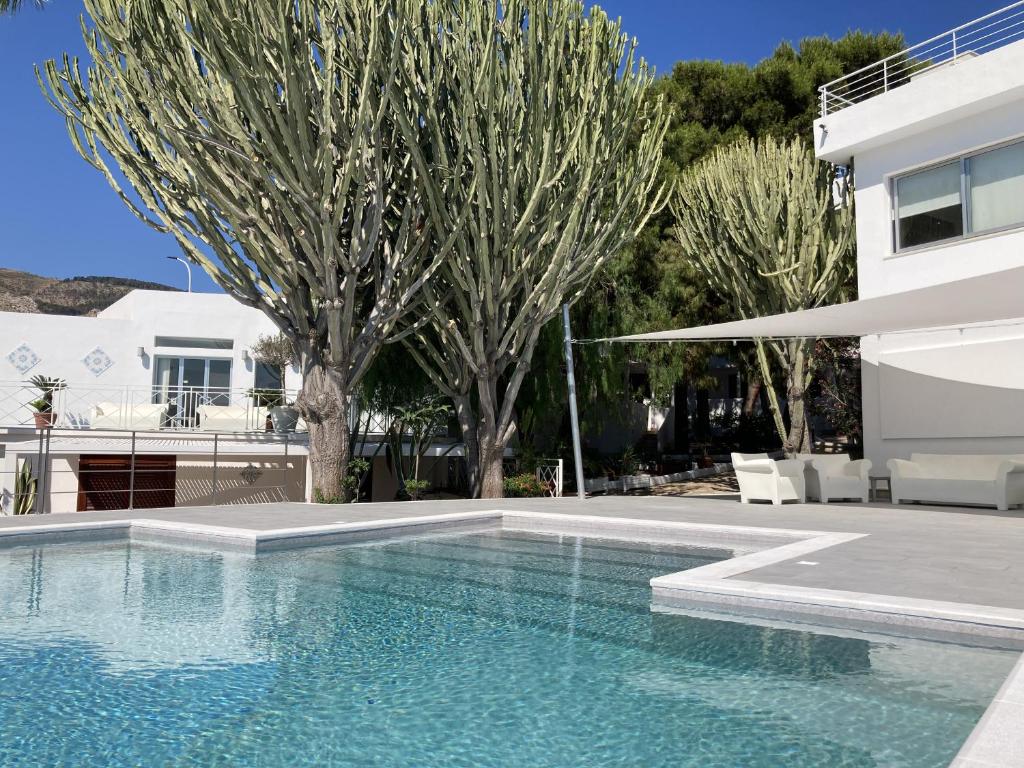 una piscina frente a una casa con árboles en Residence Tamarea, en Valderice