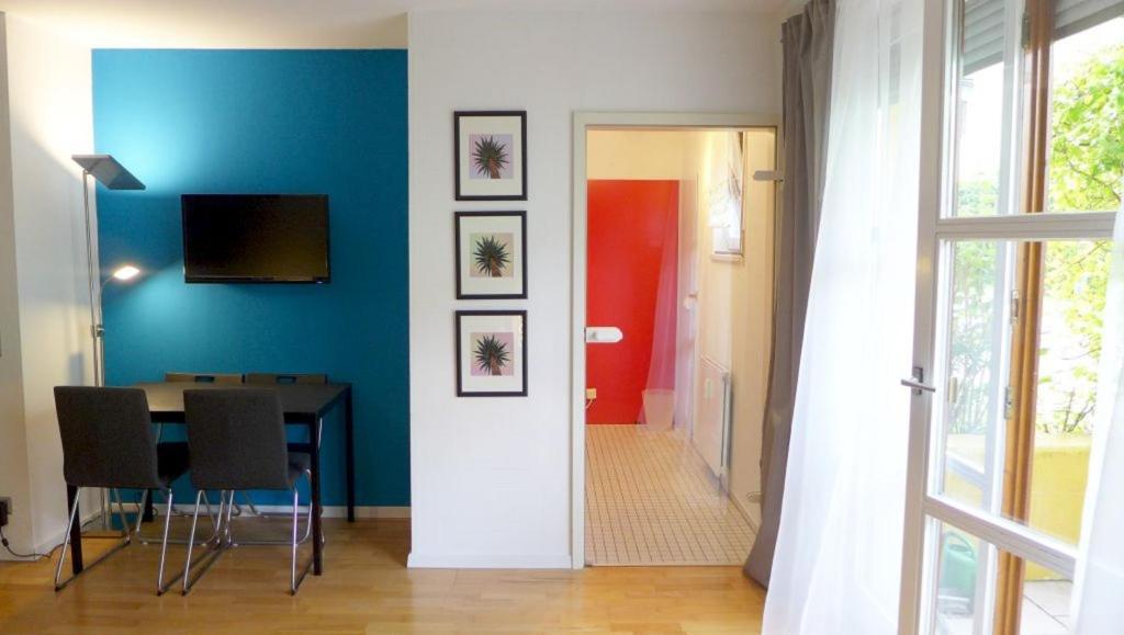 a dining room with a table and a blue wall at Apartment Blue Regensburg in Regensburg