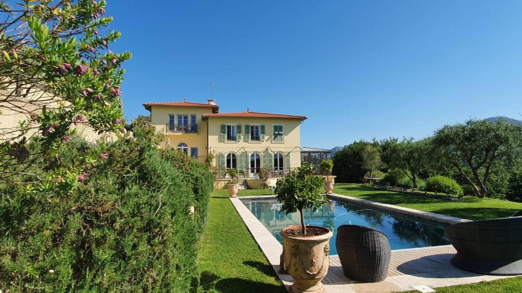une grande maison avec une piscine devant dans l'établissement Villa ELEA Suites de luxe, à Nice