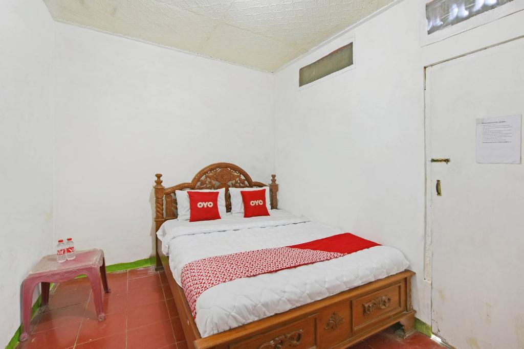 a bedroom with a bed with red pillows on it at SPOT ON 91270 Hotel Arimbi in Cilacap