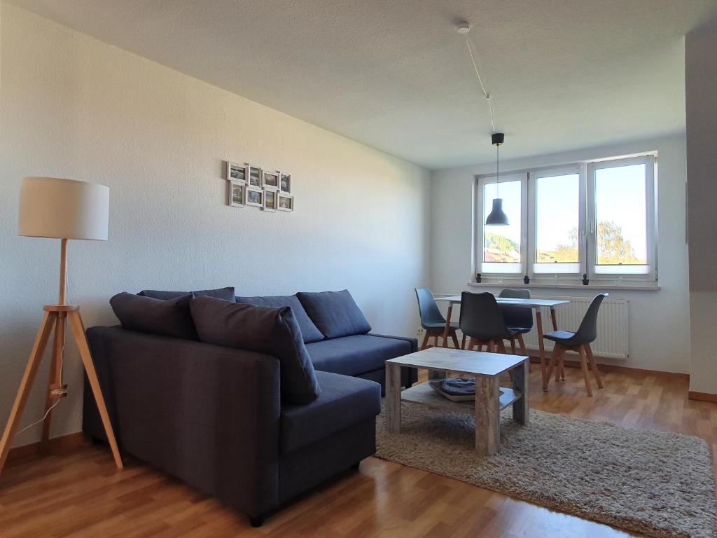 a living room with a blue couch and a table at FEWODAYs Ferienwohnung in Sassnitz - Ruegen in Sassnitz