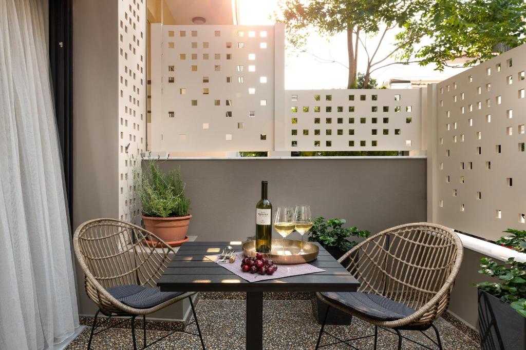 a table with two chairs and a bottle of wine at The City Gem Urban Apt. in Rhodes Town