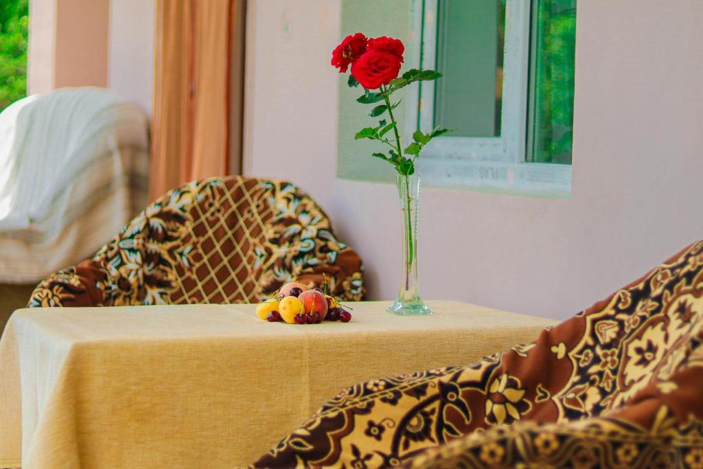 una mesa con un jarrón con una flor. en Tamara B&B, en Tumanyan