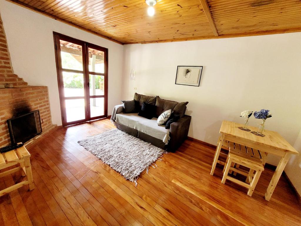 a living room with a couch and a table at Chalé, Recanto da Natureza in Gonçalves