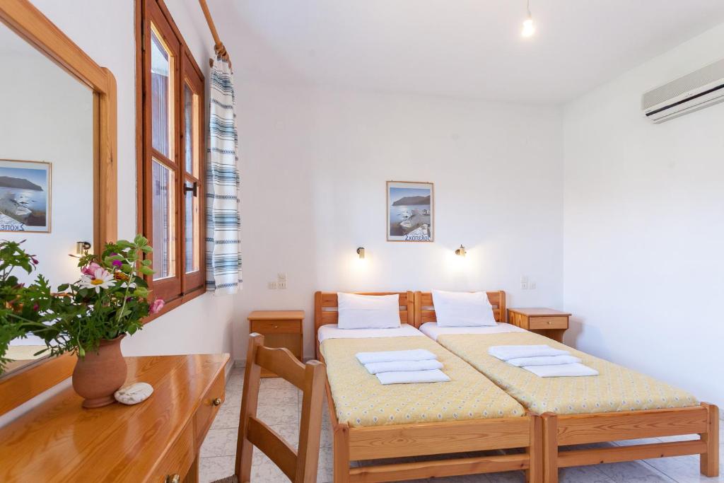 a bedroom with a bed and a table in a room at Platanakia in Skopelos Town