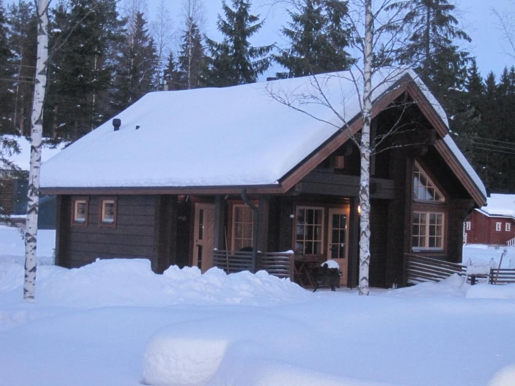 a log cabin with snow on the roof at Villa Tumppu in Jämsä