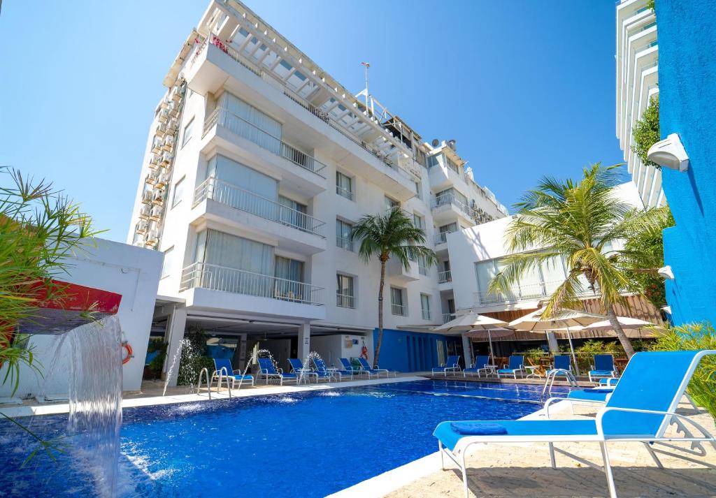 un hotel con piscina e sedie e un edificio di Hotel Santorini Resort a Santa Marta