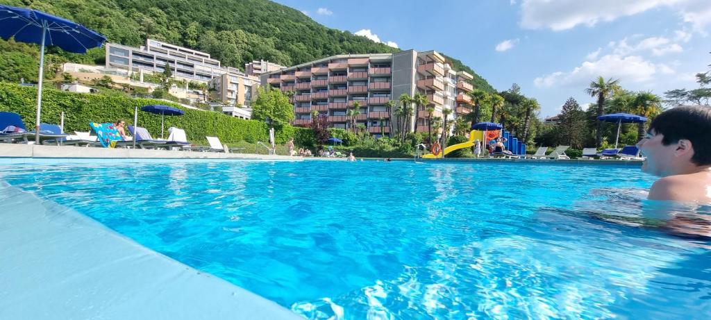 a man in a swimming pool in a resort at Bissone Apartment in Bissone