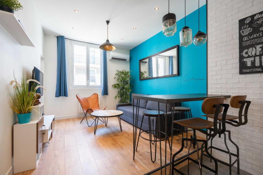 une salle à manger avec des murs bleus, une table et des chaises dans l'établissement T2 ** VIEUX PORT ** LUMINEUX, à Marseille