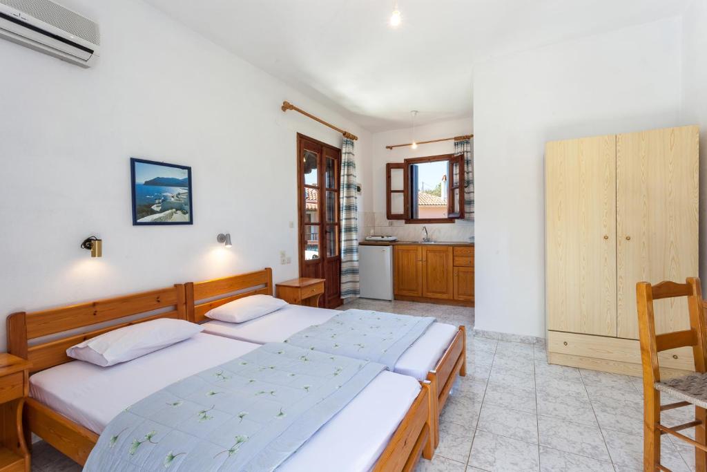 a bedroom with a large bed and a kitchen at Platanakia in Skopelos Town