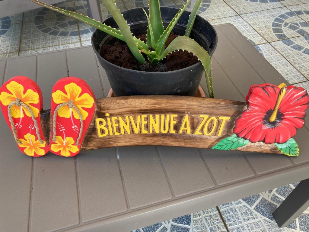 un cartel de madera que dice bernine al lado de una planta en La Petite Escale du Maïdo, en Saint-Paul