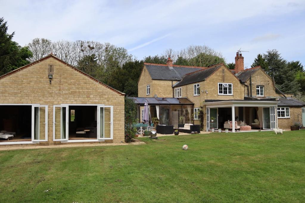 una casa con grandes puertas correderas en un patio en Bozeat Retreat & York Cottage Spa, en Bozeat