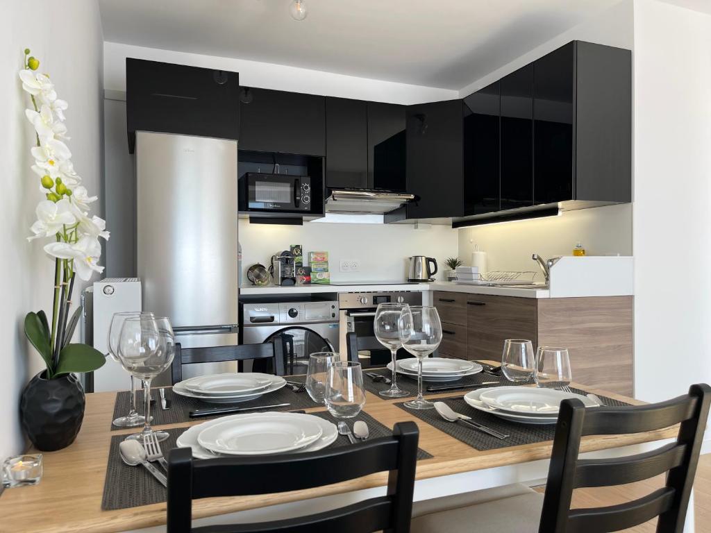 cocina con mesa de comedor con sillas y vasos en Dream House Disneyland Paris en Chessy