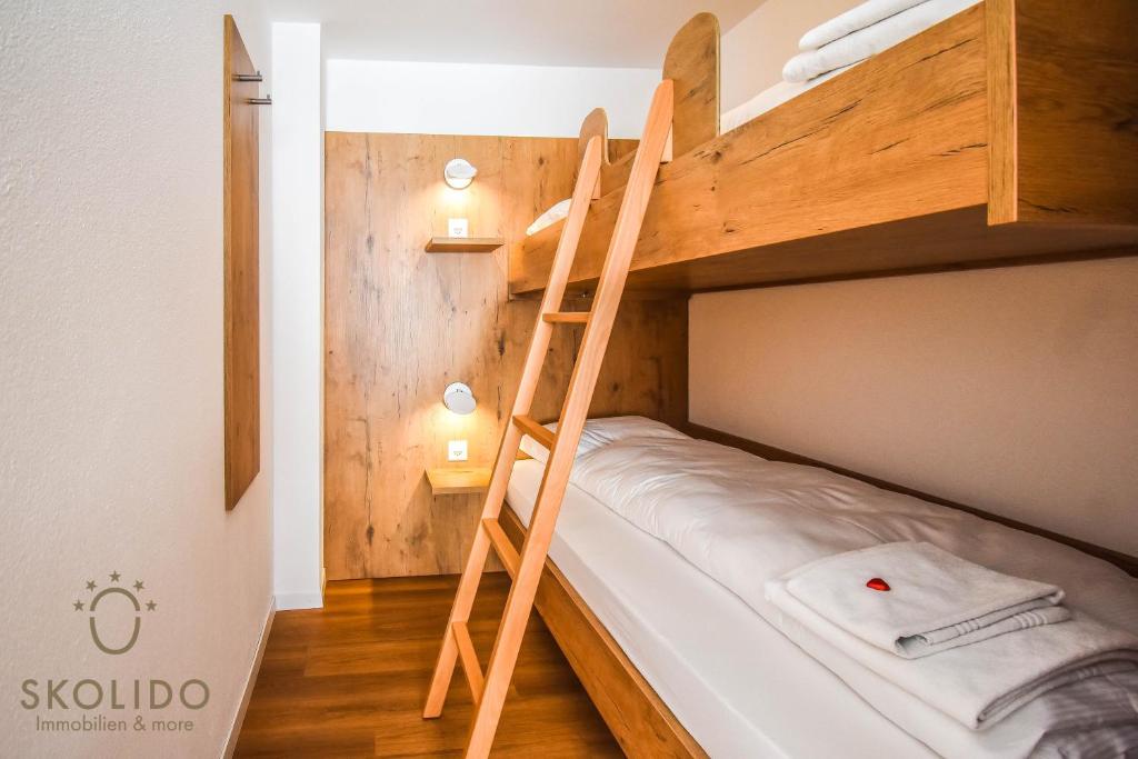 a bunk bed with a ladder in a room at Haus Camillo in Saas-Fee