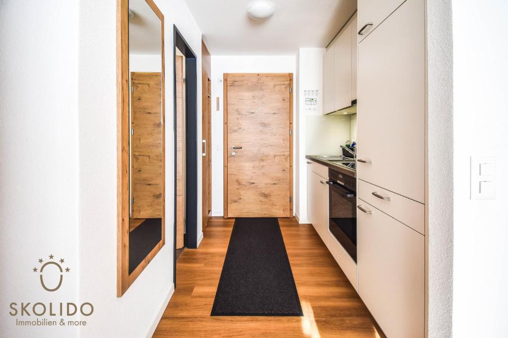 a hallway leading to a kitchen with a wooden door at Haus Camillo in Saas-Fee