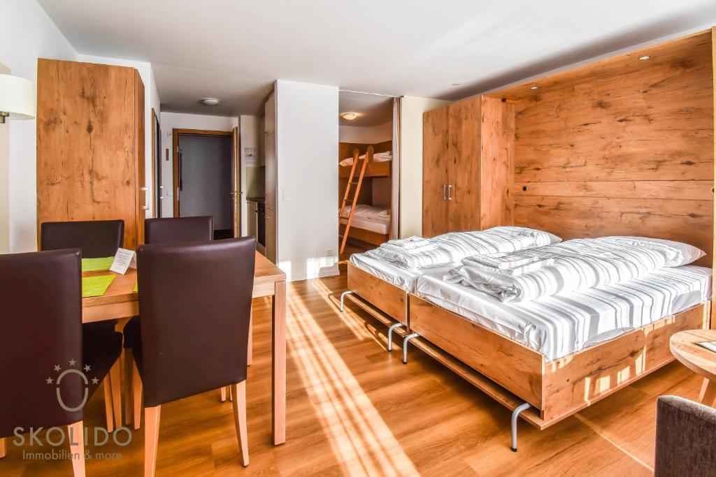 a bedroom with a bed and a table and chairs at Haus Camillo in Saas-Fee