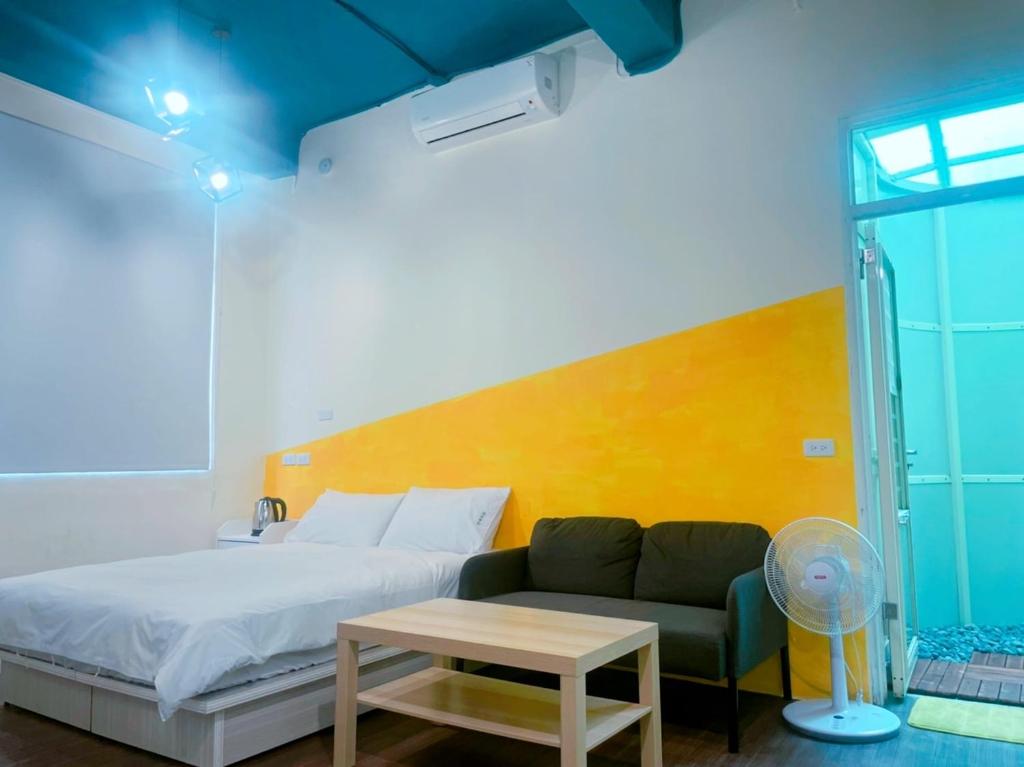 una camera da letto con un letto, un divano e un tavolo di 好客輕旅 a Donggang