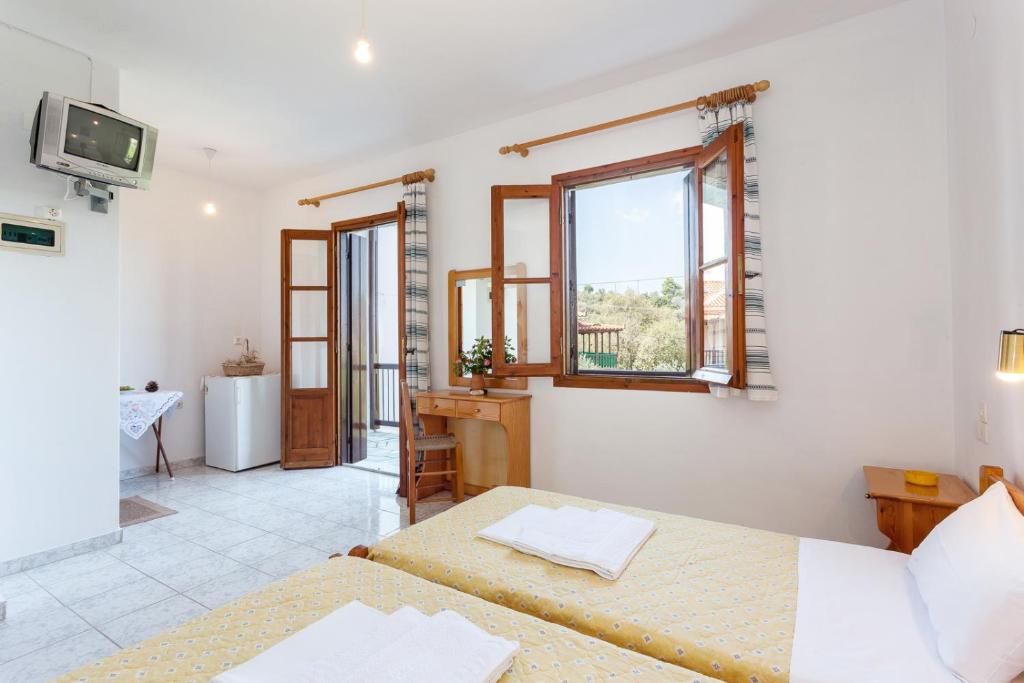 a room with two beds and a window at Platanakia in Skopelos Town