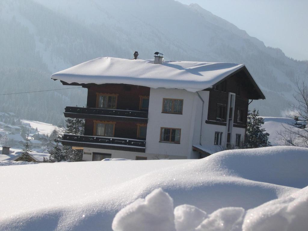 a building covered in snow with a pile of snow at Apartment Austria in Tannheim