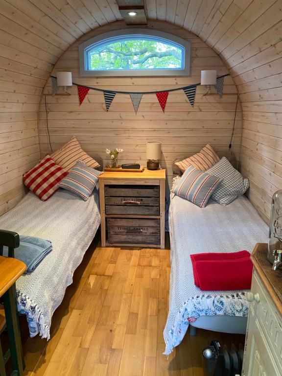 2 camas en una habitación pequeña con ventana en New Acre Pod en Angmering