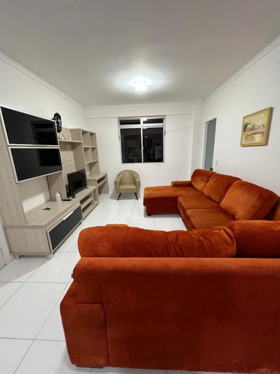 sala de estar con 2 sofás marrones y TV en Apto Central para Família, en Balneário Camboriú