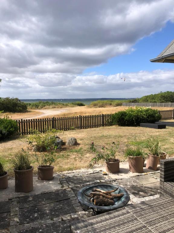 un foyer extérieur dans une cour avec une clôture dans l'établissement Beachhouse Langeland, à Tranekær