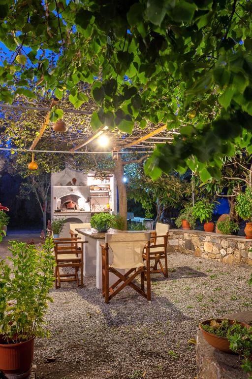 a patio with a table and chairs under a pergola at Platanakia in Skopelos Town