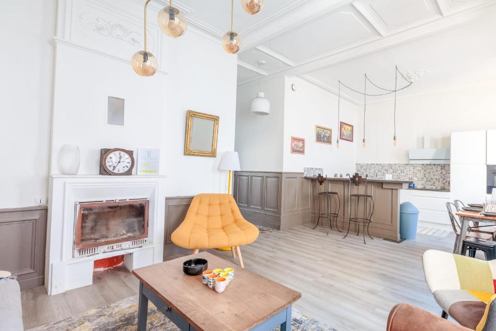 a living room with a fireplace and a table at Maison Ferry - Welkeys in Rivedoux-Plage