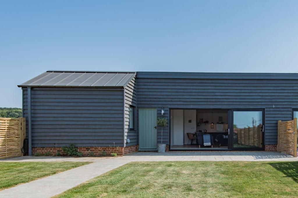 a black house with a garage at The Bull Pen by Bloom Stays in Stalisfield