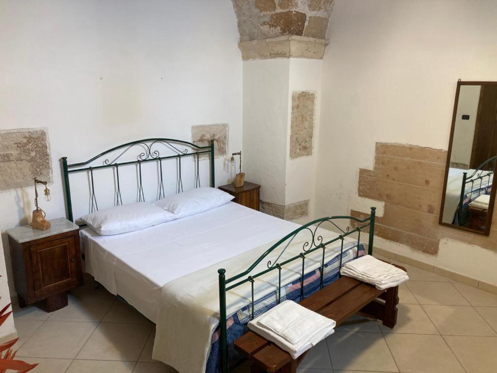 a bedroom with a bed and a table and a mirror at Otium Salento in Cutrofiano