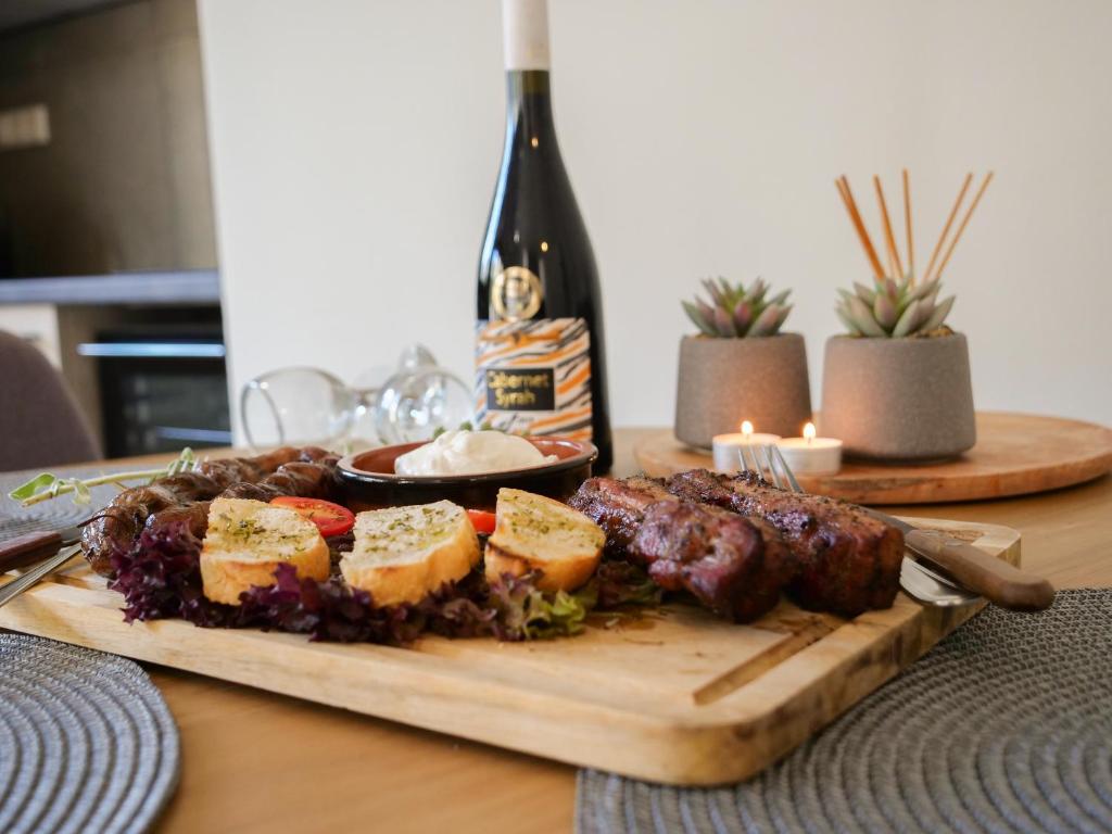 a plate of food on a table with a bottle of wine at Sisaion Suites - Live the Cretan Hospitality in Metókhion Apisianá