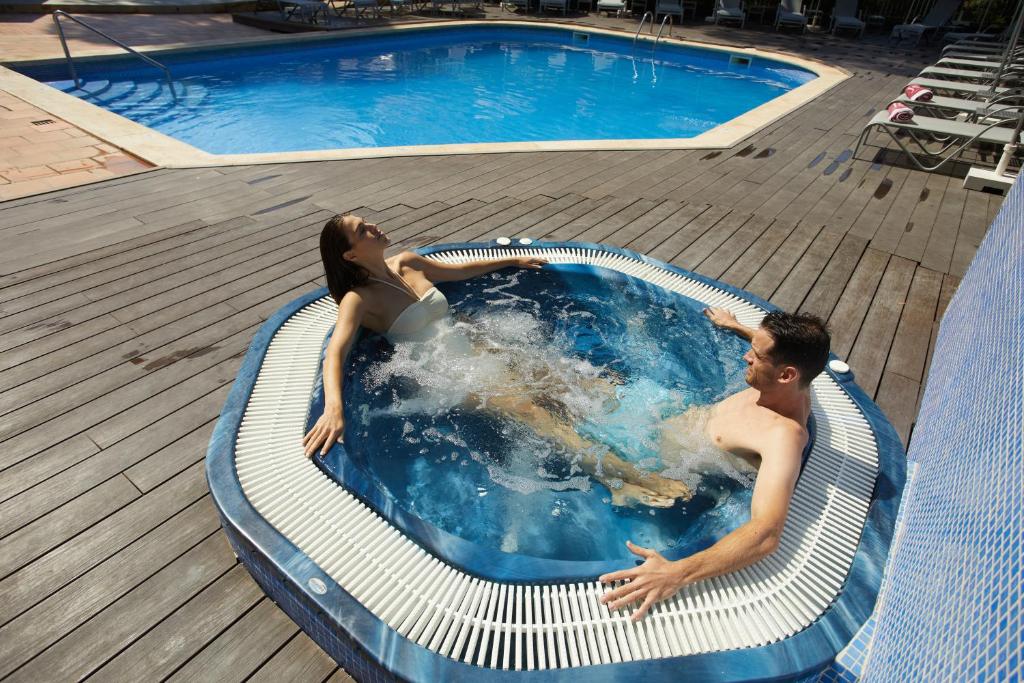 mężczyzna i kobieta w basenie w obiekcie JS Paradise Sport - Adults Only w El Arenal
