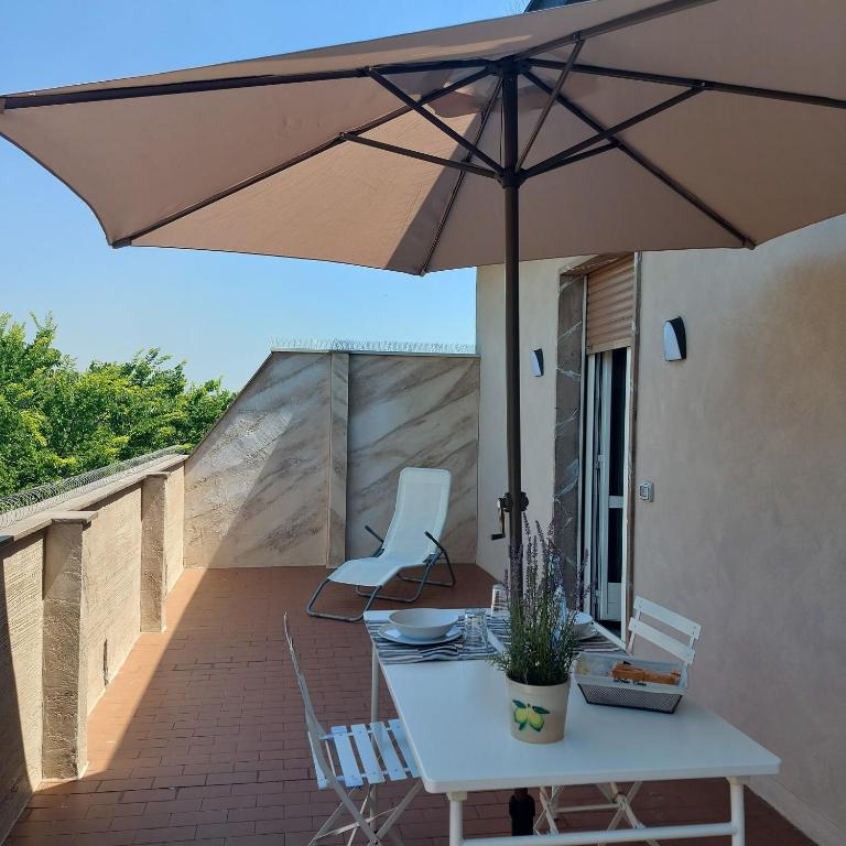 - un parasol sur une terrasse avec une table et des chaises dans l'établissement Attico Guest House, à Crémone