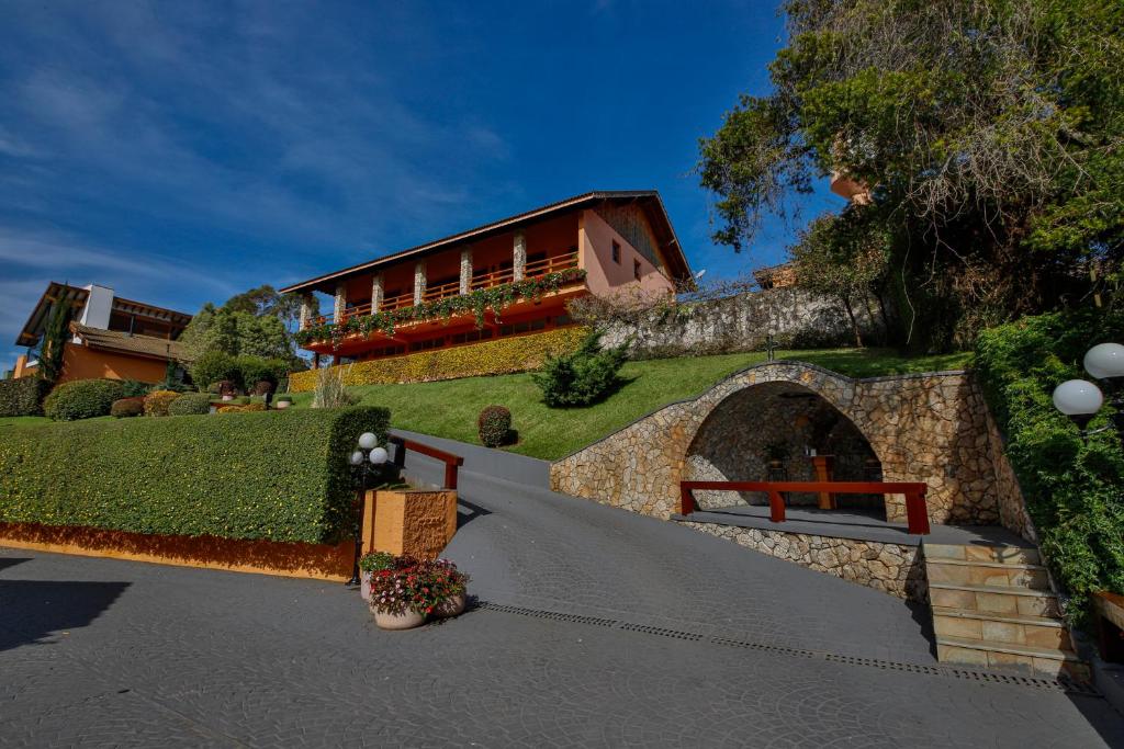 a house on a hill with a pathway and a building at Hotel Saint Michel in Monte Verde
