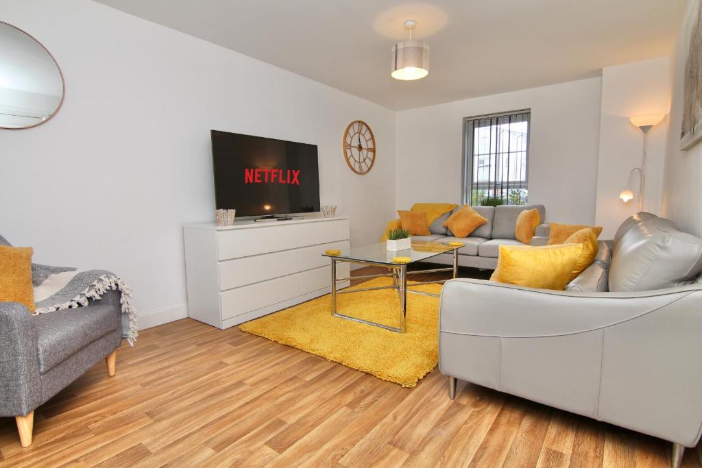 a living room with a couch and a tv at 7Bed City Gem - Walk to Coventry Center, Ultimate Holiday Comfort in Coventry