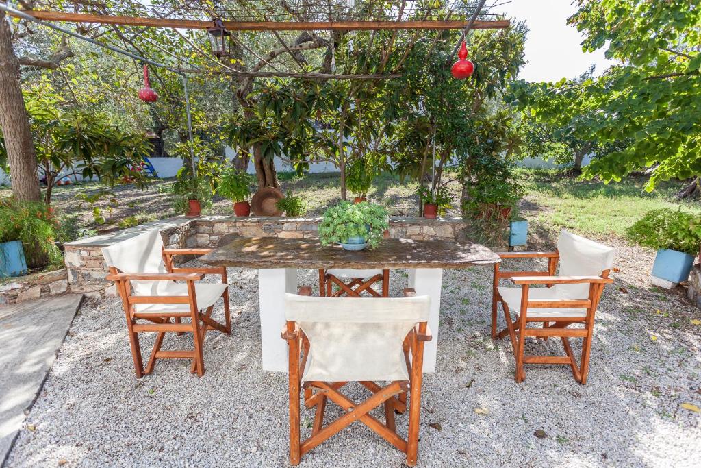 a table and chairs in a yard with trees at Platanakia in Skopelos Town