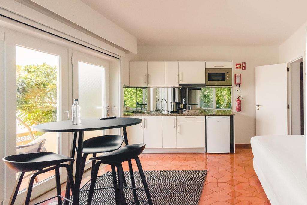 a kitchen with a table and chairs in a room at Costa d'Oiro Ambiance Village in Lagos