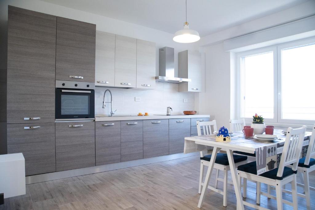 kuchnia z drewnianymi szafkami i stołem z krzesłami w obiekcie M&Mapartments w mieście Monopoli