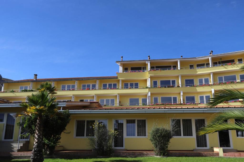 un grand bâtiment jaune avec des palmiers devant lui dans l'établissement Hotel Andino Club - Hotel Asociado Casa Andina, à Huaraz