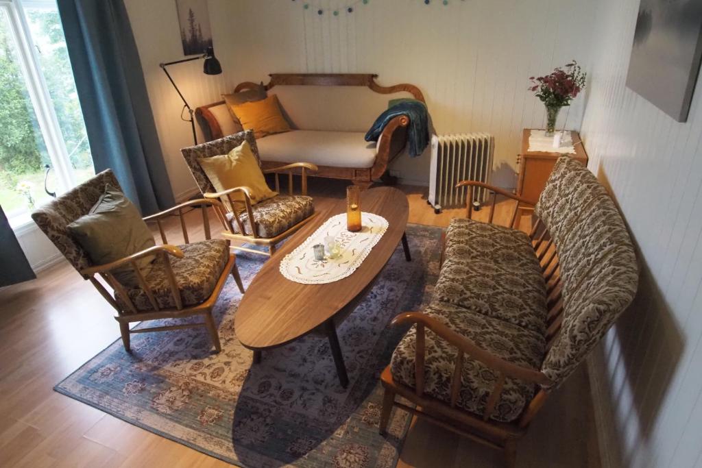 a living room with a couch and a table and chairs at Solstrand in Averoy