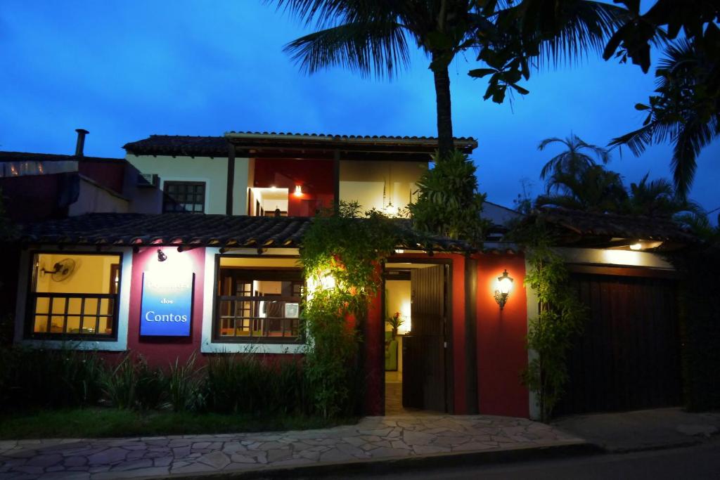 a house with a red door and a palm tree at Pousada dos Contos in Paraty