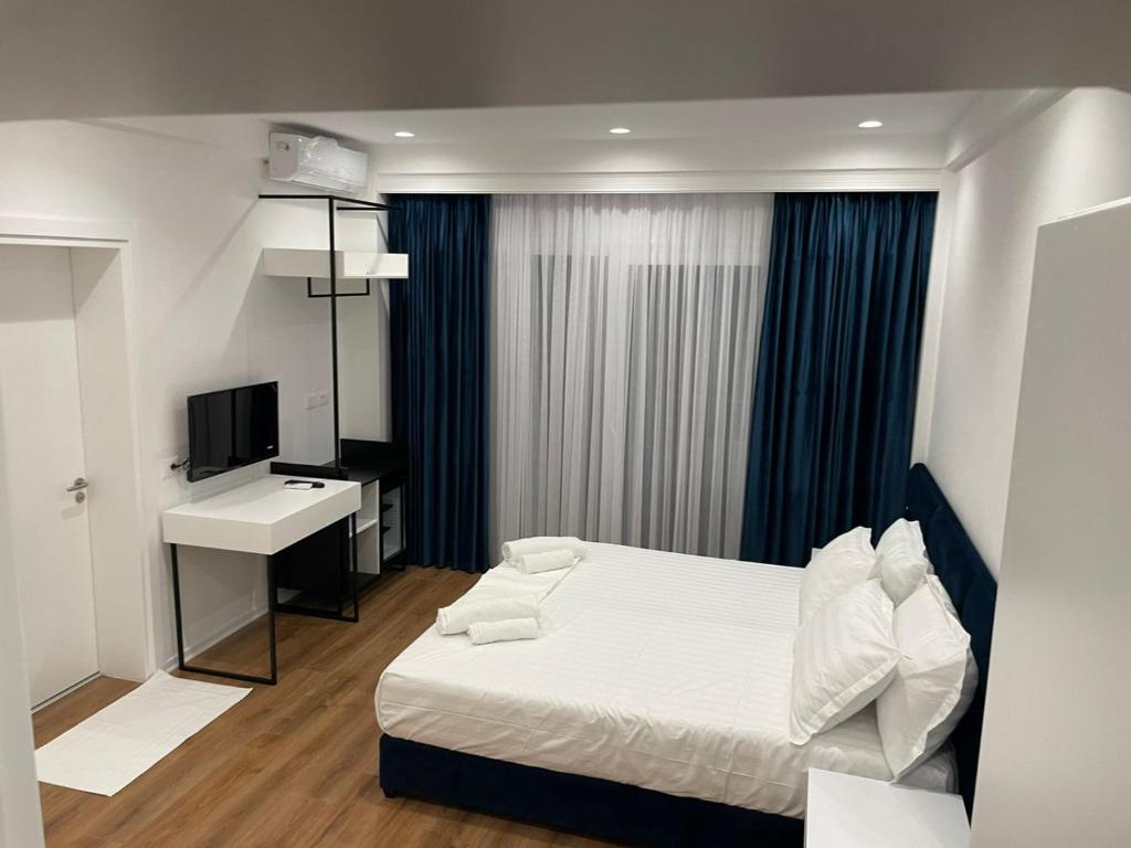 a bedroom with a bed and a desk and a sink at SEA & LAKE VIEW VILLA in (( Kalive Gjoka ))