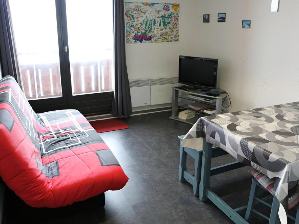 un salon avec un canapé et une télévision dans l'établissement 3 pièces au pied des pistes avec balcon et casier à skis - FR-1-557-84, à Les Adrets