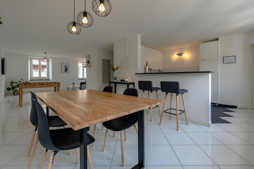 uma sala de jantar com uma mesa de madeira e cadeiras pretas em Apartment in the city center with free parking em Biel