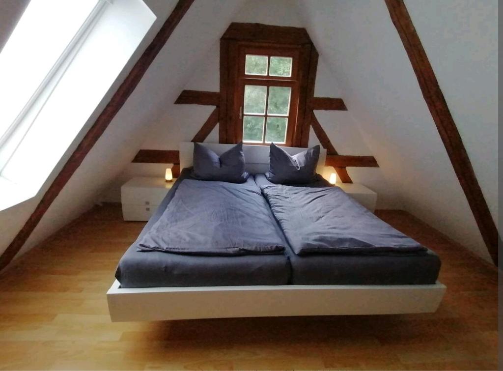 ein Schlafzimmer mit einem Bett im Dachgeschoss in der Unterkunft Loft auf altem Gutshof in Kirchensittenbach