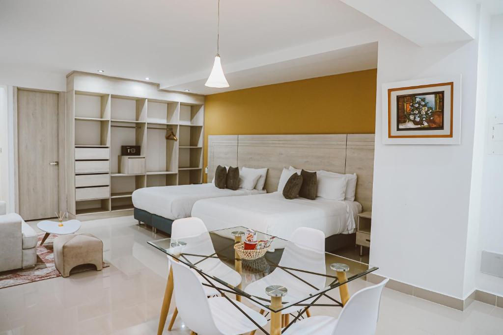 a hotel room with two beds and a table and chairs at Hotel Súper Estrellas in Barrancabermeja