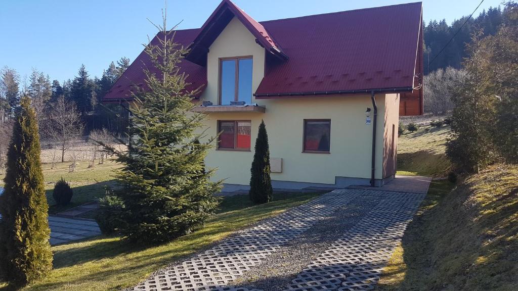 uma casa com um telhado vermelho e uma entrada em Dom na Książkowej em Jordanów
