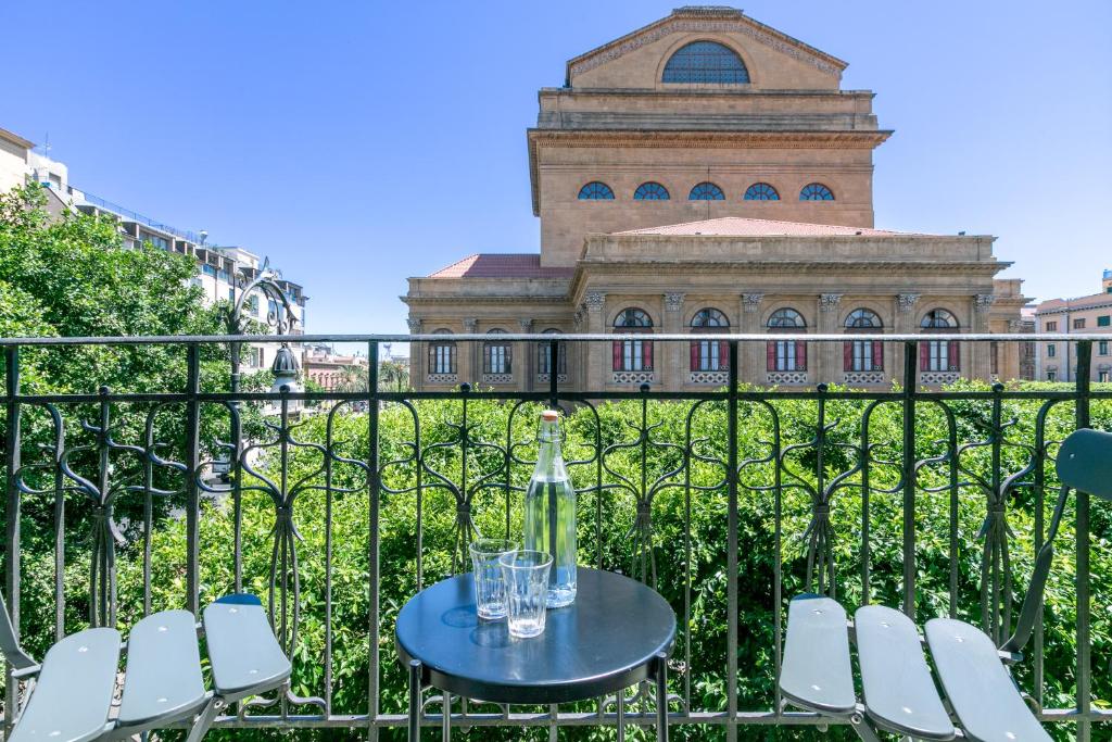 a table and chairs with a building in the background at Teatro Massimo Bright and Cozy Apartment in Palermo